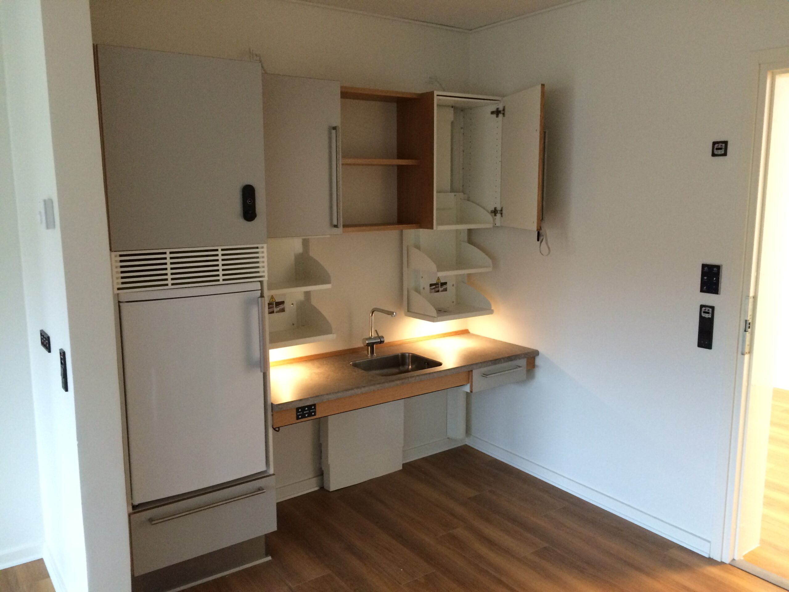 Accessible kitchen with height-adjustable cabinets and sink