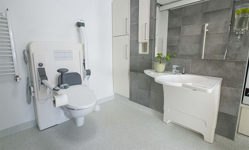 Accessible bathroom with toilet lifter and washbasin