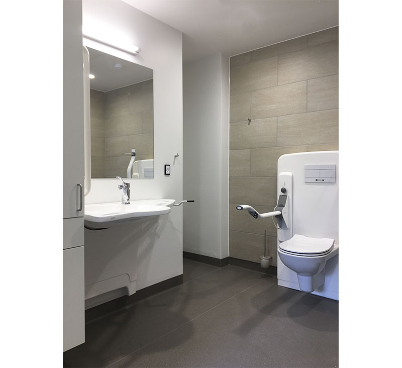 Dementia-friendly bathroom at Stenslundcentret with ROPOX SupportLine washbasin and toilet lifter